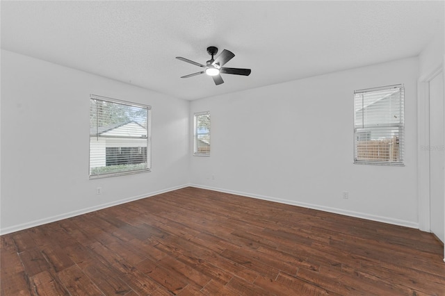 empty room with ceiling fan, dark wood-type flooring, and a textured ceiling