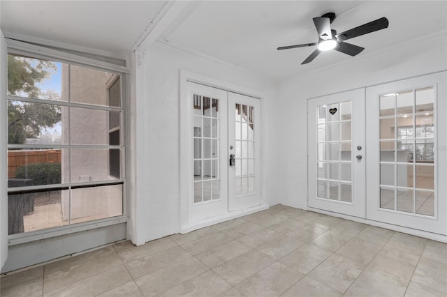 unfurnished sunroom with ceiling fan and french doors