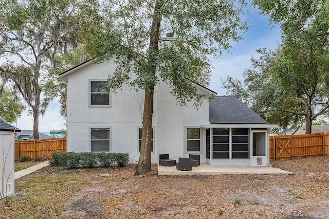 rear view of house with a patio and a sunroom