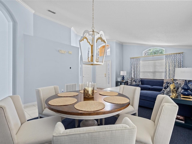 tiled dining room featuring lofted ceiling, crown molding, and an inviting chandelier