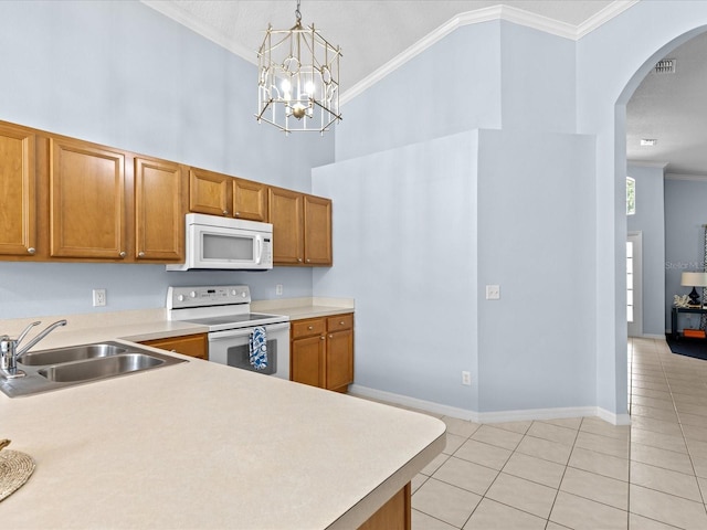 kitchen with white appliances, a chandelier, hanging light fixtures, ornamental molding, and sink