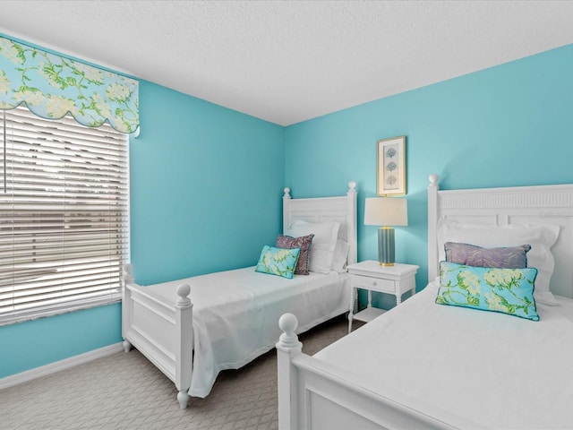 carpeted bedroom featuring multiple windows and a textured ceiling