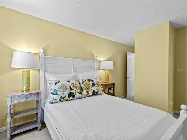 bedroom with light colored carpet and a textured ceiling