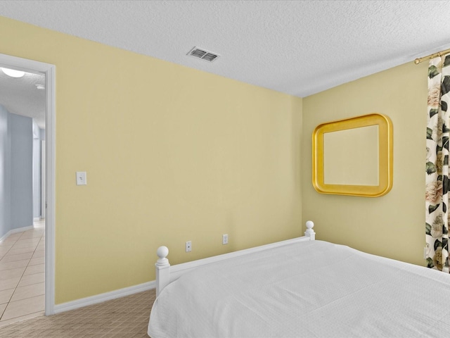 tiled bedroom featuring a textured ceiling