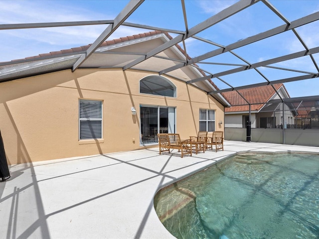 rear view of house featuring a patio area and glass enclosure