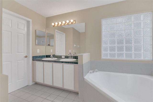 bathroom featuring vanity, tiled tub, plenty of natural light, and tile patterned flooring