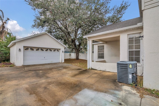 view of property exterior with a garage, an outbuilding, and central AC