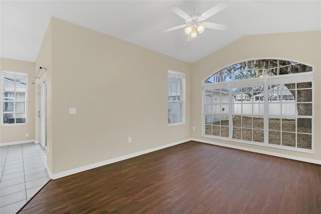 spare room with ceiling fan, a wealth of natural light, hardwood / wood-style floors, and vaulted ceiling