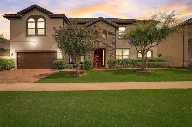 mediterranean / spanish house with a yard and a garage