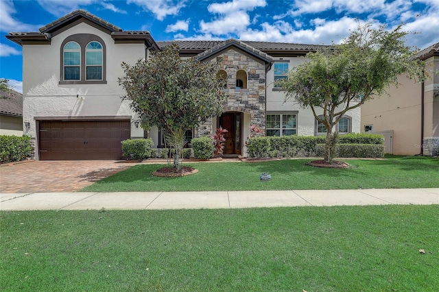 mediterranean / spanish home with a garage and a front lawn