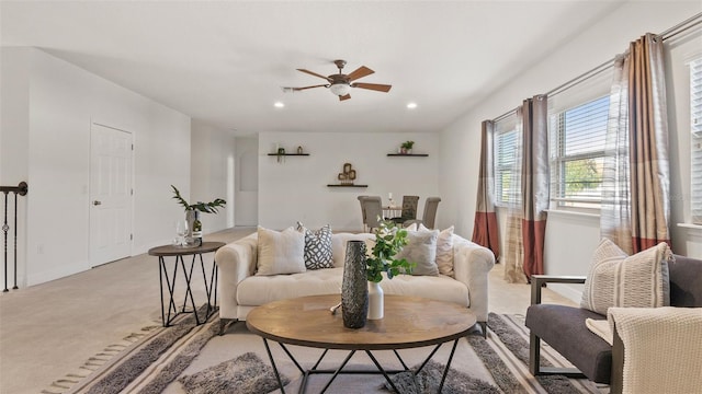 carpeted living room with ceiling fan