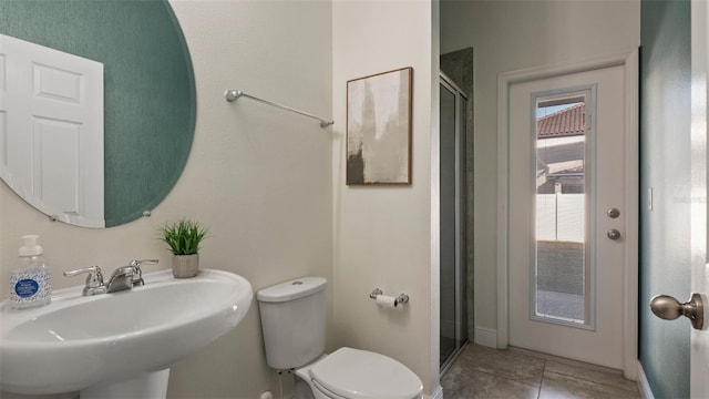 bathroom featuring walk in shower, sink, tile patterned floors, and toilet