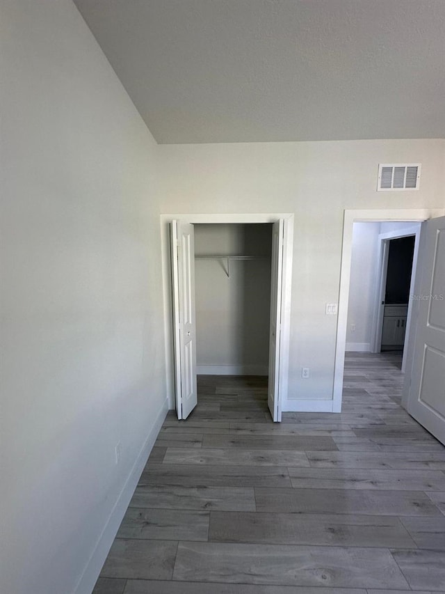 unfurnished bedroom with a closet and hardwood / wood-style floors