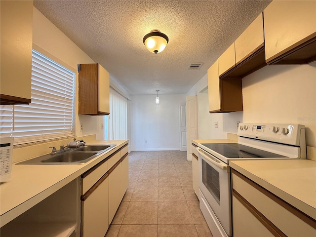 kitchen featuring light tile patterned floors, electric range, sink, and a textured ceiling