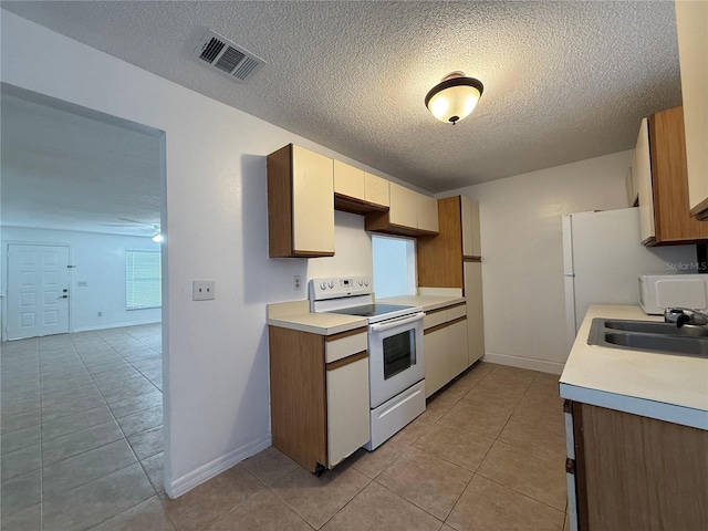 kitchen featuring light tile patterned floors, sink, and white appliances