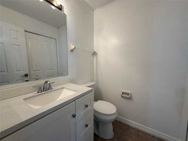 bathroom featuring toilet, vanity, tile patterned flooring, and a textured ceiling