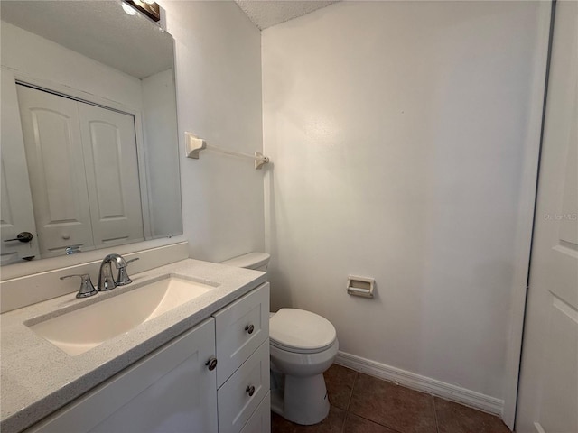 bathroom featuring a textured ceiling, tile patterned floors, vanity, and toilet