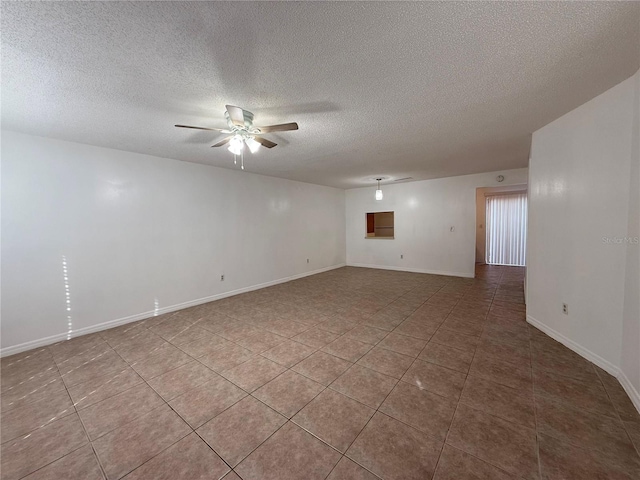 tiled empty room with ceiling fan and a textured ceiling