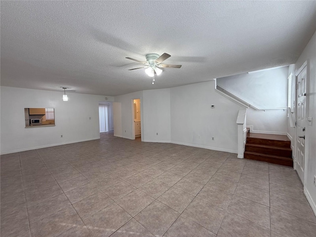 unfurnished living room featuring ceiling fan, a textured ceiling, and light tile patterned floors