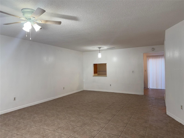 unfurnished room featuring ceiling fan, tile patterned flooring, and a textured ceiling