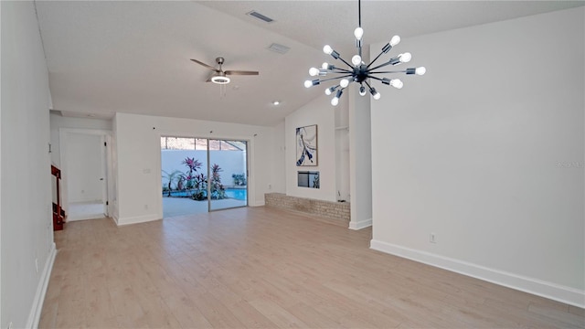 unfurnished living room with ceiling fan with notable chandelier, light hardwood / wood-style floors, lofted ceiling, and a brick fireplace