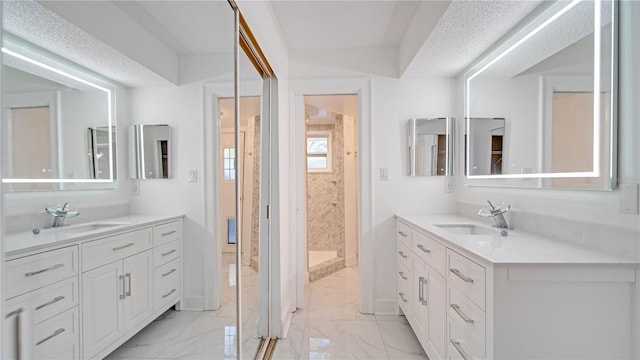 bathroom with walk in shower, vanity, and a textured ceiling