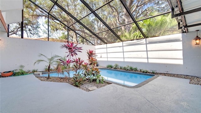 view of pool with glass enclosure and a patio