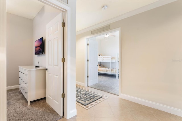 hallway featuring light carpet and crown molding