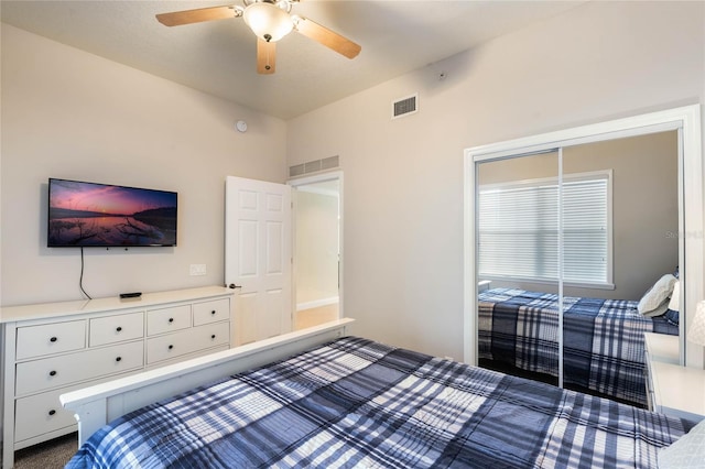 carpeted bedroom with ceiling fan and a closet