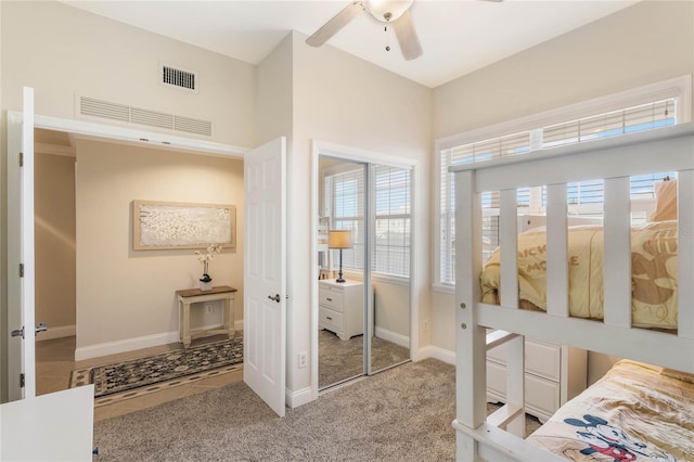 carpeted bedroom featuring ceiling fan and a closet