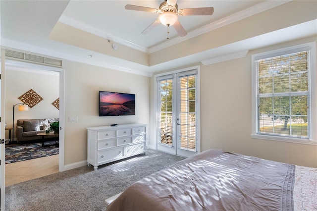 bedroom featuring ceiling fan, a tray ceiling, french doors, and access to outside