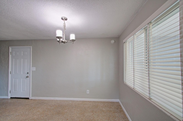 unfurnished room featuring a textured ceiling and an inviting chandelier