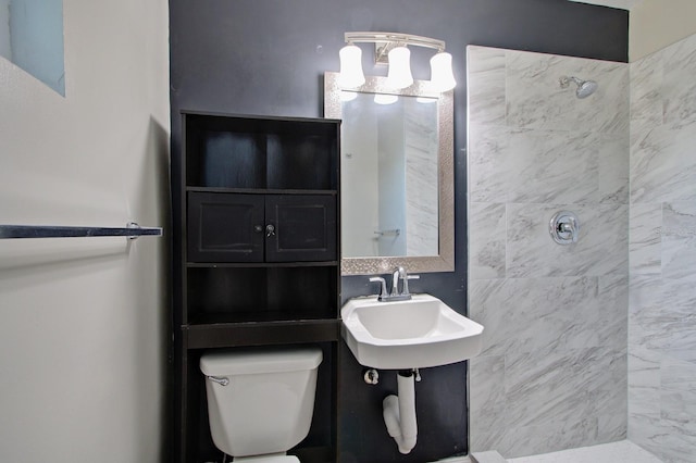 bathroom with toilet, sink, and a tile shower