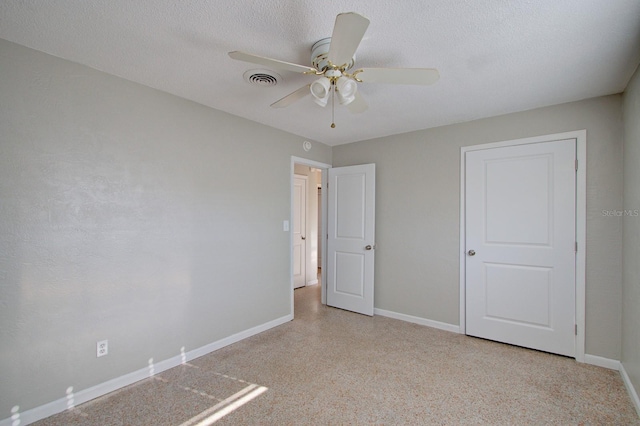 unfurnished bedroom with ceiling fan and a textured ceiling