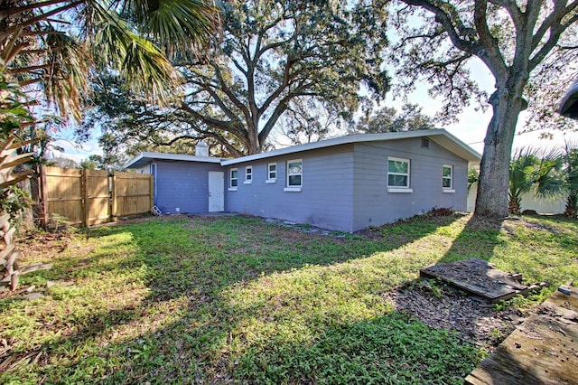 back of house featuring a lawn