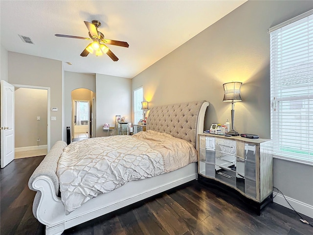 bedroom featuring ceiling fan, dark hardwood / wood-style floors, and multiple windows