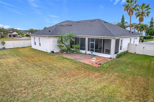 back of house featuring a sunroom, a patio area, and a lawn