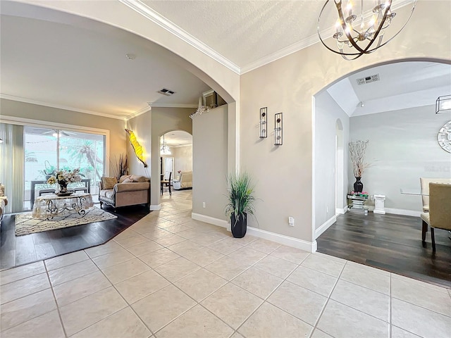 hallway with light tile patterned floors, crown molding, and a textured ceiling