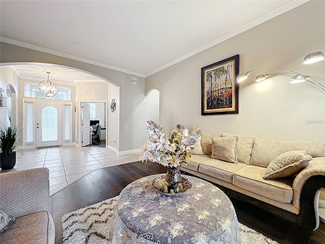 living room with ornamental molding, a chandelier, and light hardwood / wood-style floors