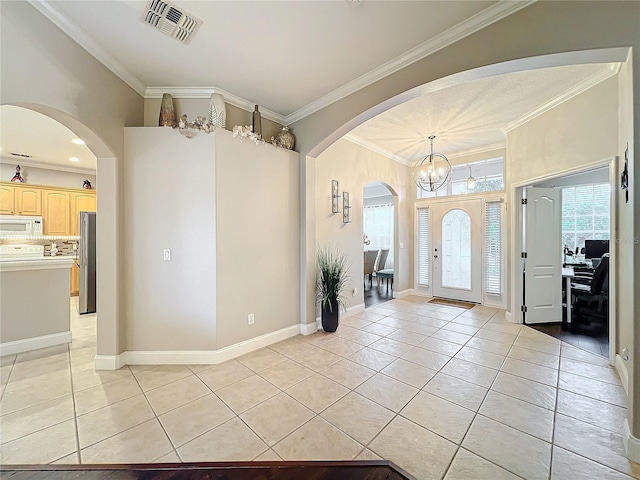 entryway with ornamental molding, a healthy amount of sunlight, and light tile patterned floors