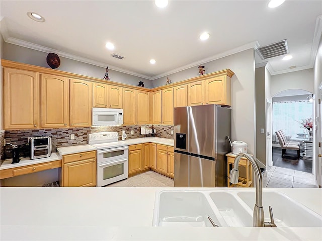 kitchen featuring light tile patterned floors, white appliances, crown molding, light brown cabinetry, and decorative backsplash