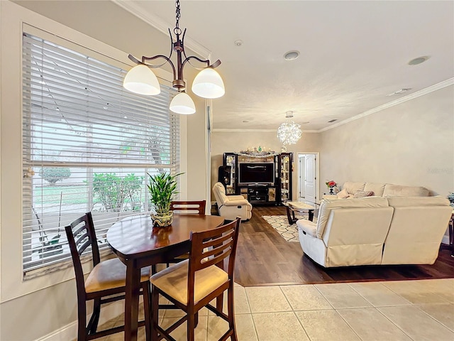 dining space featuring a notable chandelier, crown molding, and tile patterned floors