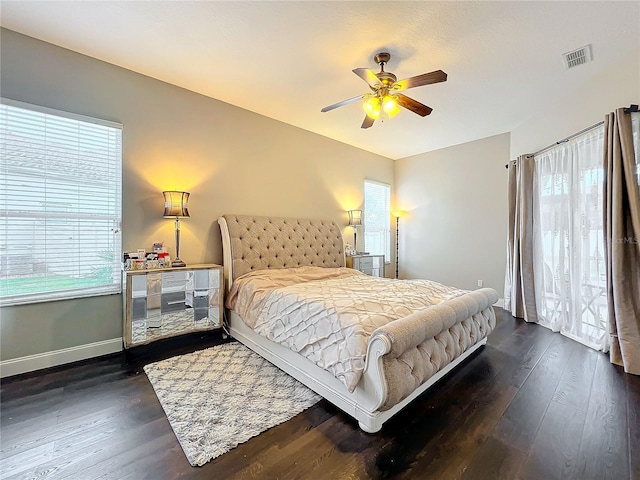 bedroom with ceiling fan, dark hardwood / wood-style flooring, and multiple windows