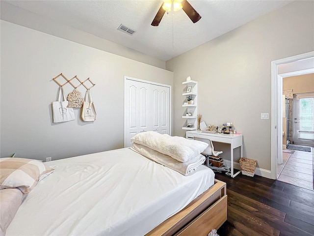 bedroom featuring dark hardwood / wood-style floors, a textured ceiling, ceiling fan, and a closet