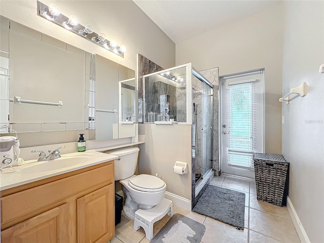 bathroom featuring tile patterned flooring, vanity, a shower with shower door, and toilet