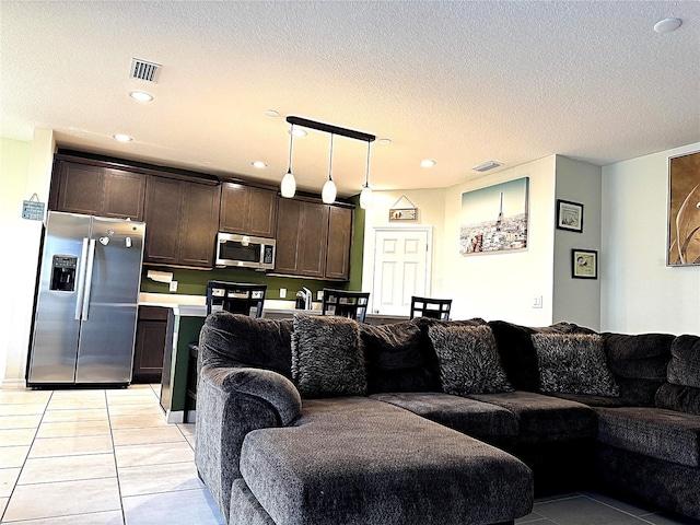 living room with a textured ceiling and light tile patterned floors