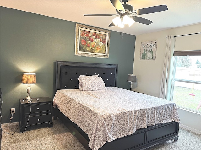 carpeted bedroom featuring multiple windows and ceiling fan