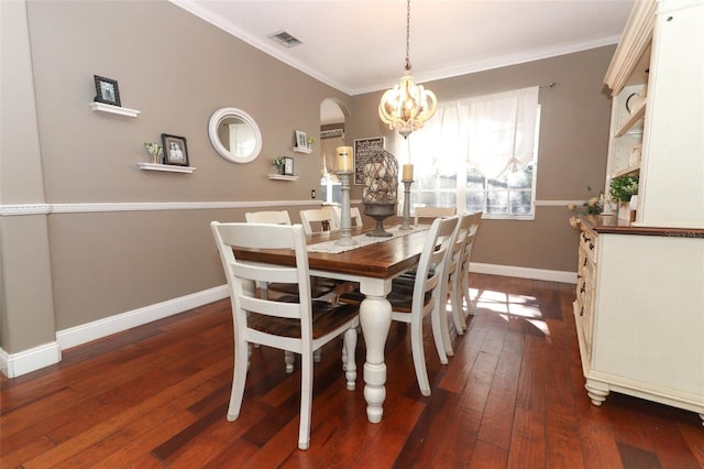 dining room with dark hardwood / wood-style floors, an inviting chandelier, and ornamental molding