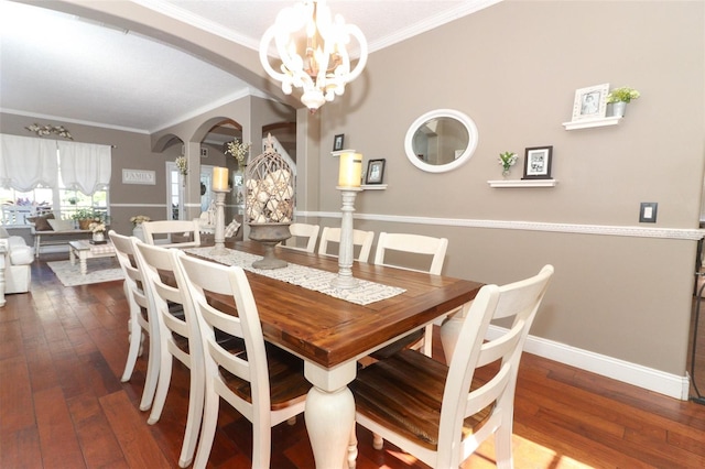 dining room with hardwood / wood-style floors, ornamental molding, and an inviting chandelier