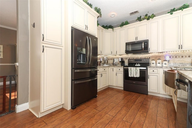 kitchen featuring appliances with stainless steel finishes, white cabinetry, tasteful backsplash, dark hardwood / wood-style floors, and light stone counters